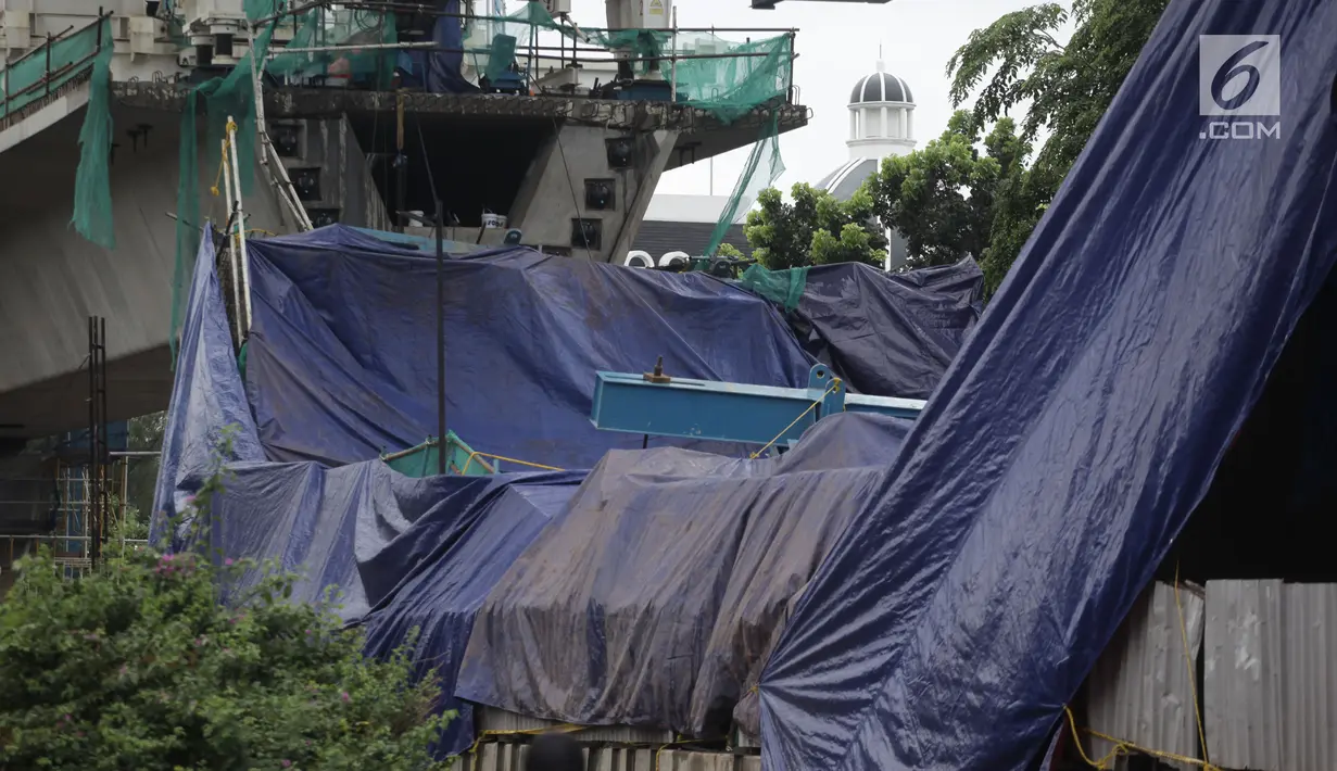 Terpal menutupi box girder beton proyek LRT yang roboh di Kayu Putih, Jakarta, Senin (22/1). Jalur LRT itu merupakan bagian dari penghubung Kelapa Gading - Velodrome yang rencananya digunakan sebagai persiapan ASEAN Games. (Liputan6.com/Arya Manggala)