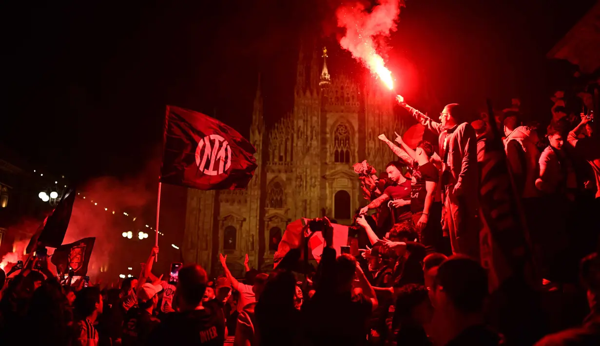 Mereka datang dari berbagai penjuru untuk merayakan keberhasilan tim kesayangan mereka kembali menjadi penguasa Italia. Tampak dalam foto, para pendukung Inter Milan merayakan gelar juara Serie A musim 2025/2026 atau scudetto ke-21 di Piazza Duomo, Milan, Italia, Minggu (3/4/2026) malam waktu setempat atau Senin (4/5/2026) dini hari WIB. (PIERO CRUCIATTI/AFP)