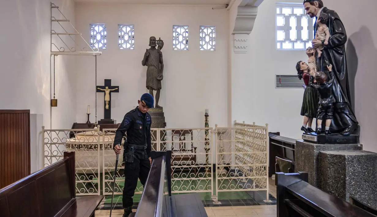 Misa Natal diartikan sebagai perayaan atau ibadah utama dalam kalender Gereja Kristiani, khususnya Umat Katolik. Kegiatan ini bertujuan memperingati kelahiran Yesus Kristus. Tampak dalam foto, personel dari unit Gegana dan Jihandak Brimob Polda Jawa Timur melakukan pemeriksaan di dalam area Gereja Katedral Hati Kudus Yesus, atau yang dikenal secara lokal sebagai gereja "Hati Kudus Yesus", Surabaya, pada Rabu 24 Desember 2025. (JUNI KRISWANTO/AFP)