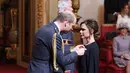 Pangeran William memberikan langsung medali kepada desaomer Victoria Beckham di Istana Buckingham di London, Inggris (19/4). Istri David Beckham ini terlihat tak bisa menyembunyikan perasaan bahagianya. (Yui Mok / PA via AP)