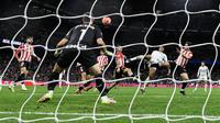 Gelandang Real Madrid asal Inggris Jude Bellingham (2R) melepaskan tembakan ke gawang tetapi gagal melewati kiper Athletic Bilbao asal Spanyol Unai Simon selama pertandingan sepak bola liga Spanyol antara Real Madrid CF dan Athletic Club Bilbao di Stadion Santiago Bernabeu di Madrid, pada 20 April 2025.OSCAR DEL POZO / AFP