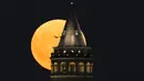 Bulan purnama terbesar atau supermoon muncul di belakang Menara Galata di Istanbul, Turki, Senin, 19 Agustus 2024. (AP Photo/Khalil Hamra)