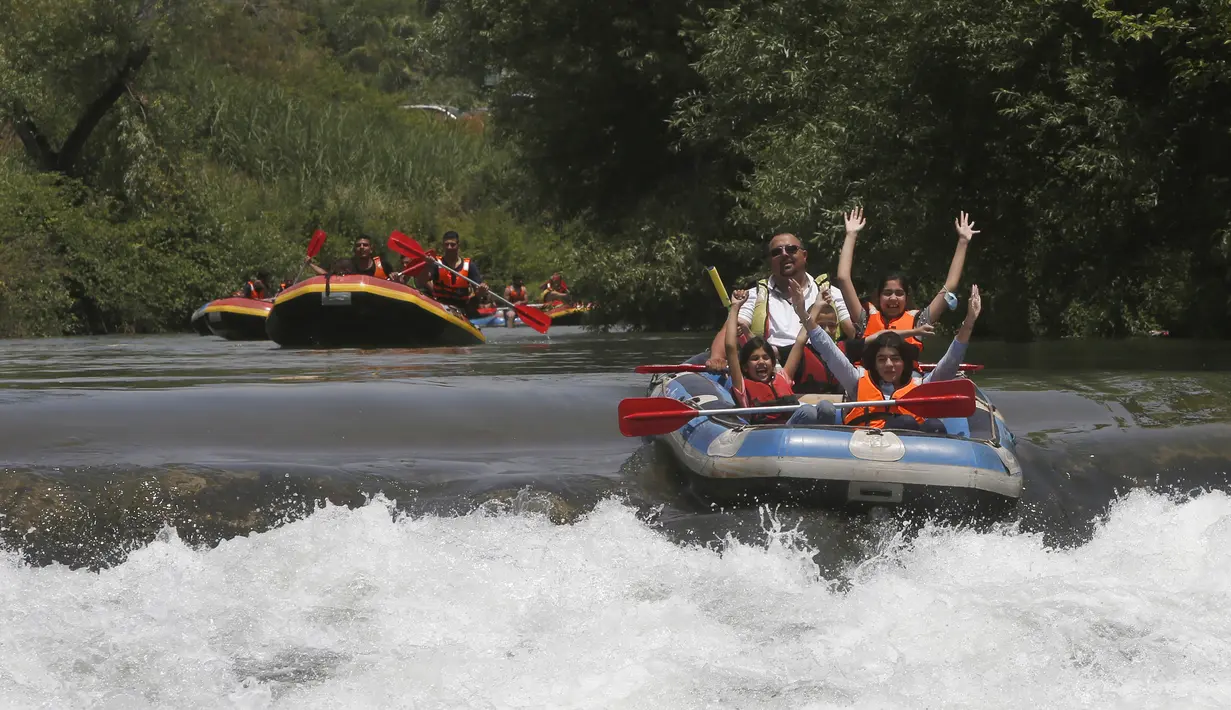 Umat muslim merayakan liburan Idul Fitri dengan rafting menyusuri Sungai Hasbani, Anak Sungai Yordan, di Kfar Blum, Israel, Rabu (27/5/2020). Pemerintah Israel mengurangi pembatasan aktivitas terkait pandemi virus corona COVID-19. (JALAA MAREY/AFP)