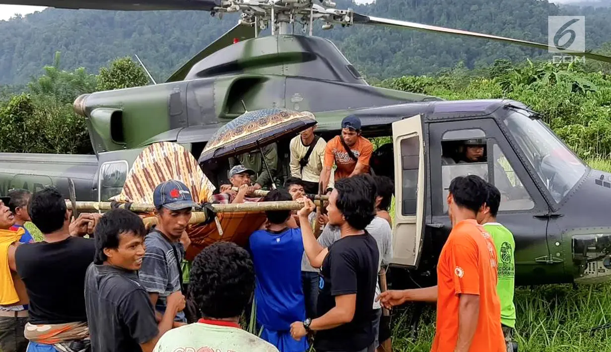 Warga mengevakuasi Heriani yang akan melahirkan saat tiba menggunakan helikopter di Dusun Air Teh, Sulawesi Tengah, Sabtu (27/7/2019). Evakuasi berawal saat Tim Penerbad menerima perintah untuk melakukan dorongan logistik bagi pasukan Satgas Tindak. (Liputan6.com/HO/Satgas TNI-Tinombala)