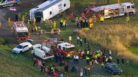 Petugas penyelamat membantu anak-anak dari bus sekolah setelah kecelakaan di pinggiran Melbourne, Australia. (AP)