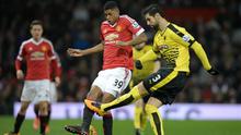 Striker Manchester United, Marcus Rashford, berebut bola dengan bek Watford, Miguel Britos, pada laga Premier League di Old Trafford, Manchester, Kamis (3/3/2016) dini hari WIB. (AFP/Oli Scarff)
