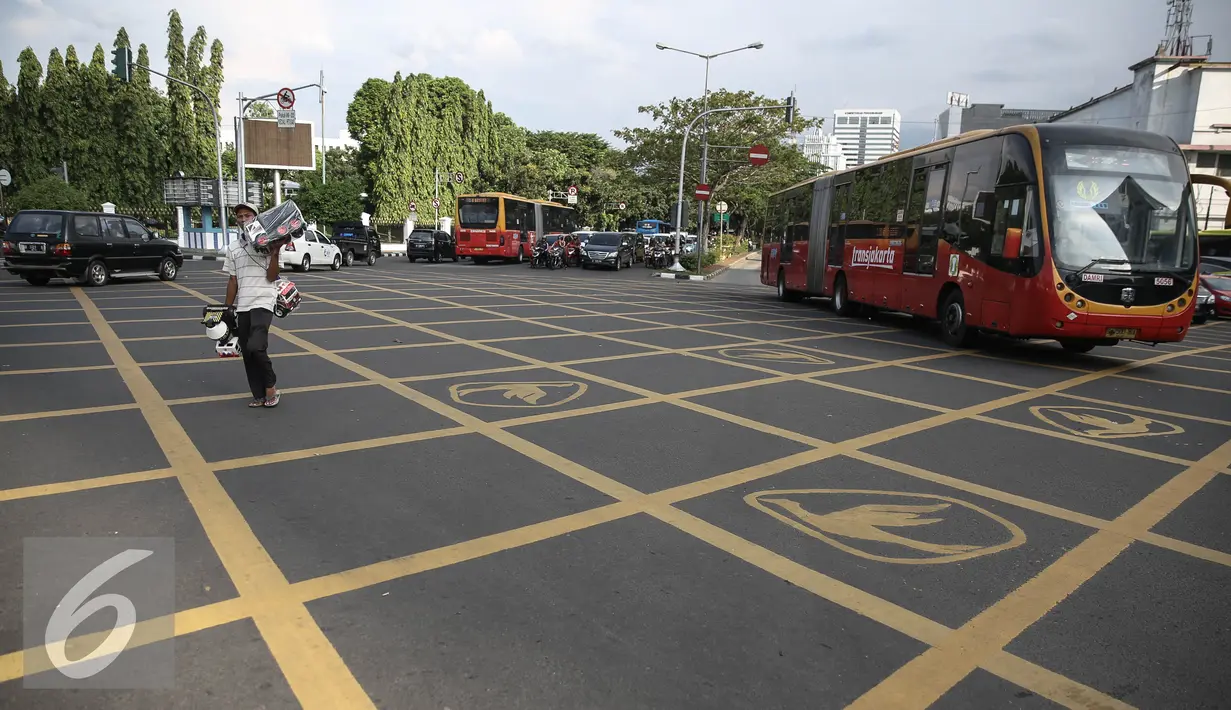 Bus Transjakarta melintasi Yello Box Junction berlambang burung dikawasan Harmoni, Jakarta, Rabu (27/4/2016). Yellow box junction tersebut merupakan bagian dari program corporate social responsibility (CSR) dari Blue Bird. (Liputan6.com/Faizal Fanani)