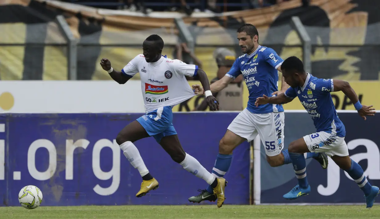 Gelandang Arema Malang, Makan Konate, ditarik oleh gelandang Persib Bandung, Srdan Lopicic, pada laga Piala Indonesia di Stadion Si Jalak Harupat, Bandung, Senin (18/2). Persib bermain imbang 1-1 melawan Arema. (Bola.com/Vitalis Yogi Trisna)