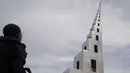 Seorang wisatawan mengamati karya seni patung yang dipamerkan di taman gurun wilayah Minqin, Provinsi Gansu, China, 5 September 2020. Kamp Pembuatan Patung Gurun Internasional Ketiga (Third Desert Sculpture International Creation Camp) dibuka di Minqin pada 5 September 2020. (Xinhua/Huang Zemin)