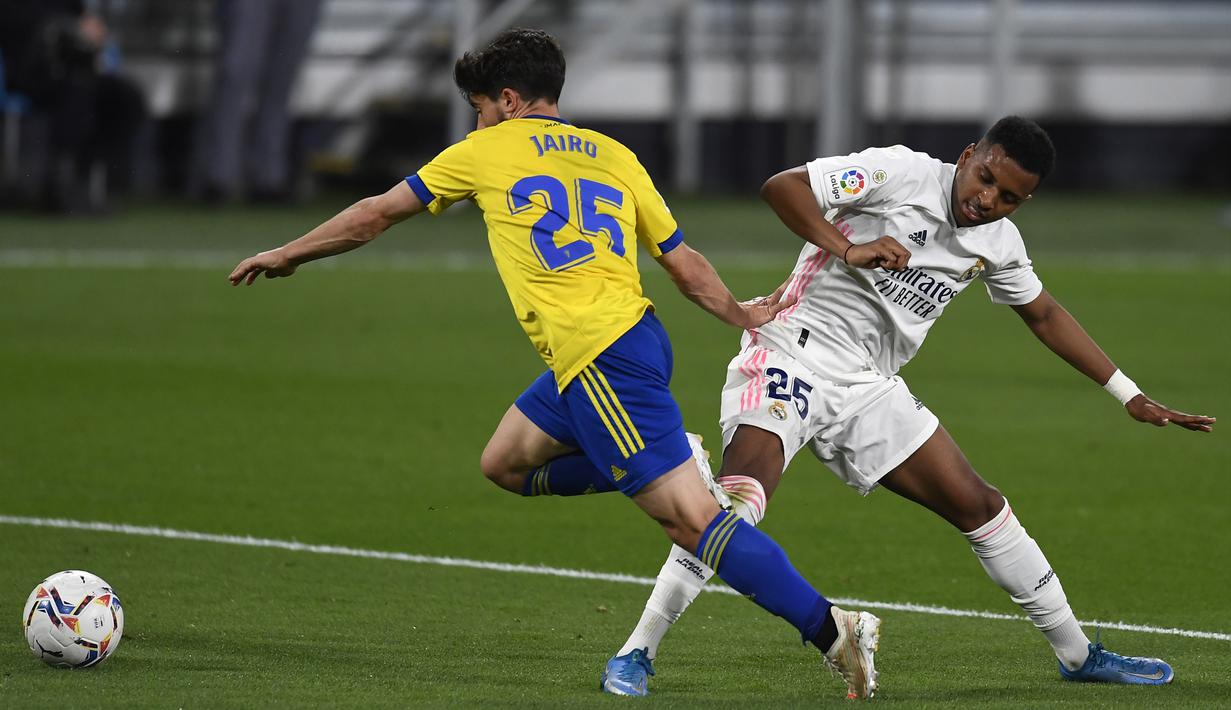 Pemain Real Madrid Rodrygo (kanan) memperebutkan bola dengan pemain Cadiz Jairo Izquierdo pada pertandingan La Liga Spanyol di Stadion Ramon Carranza, Cadiz, Spanyol, Rabu (21/4/2021). Real Madrid menang 3-0. (AP Photo/Jose Breton)