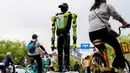 Inovasi ini diharapkan dapat meningkatkan efisiensi, keselamatan, serta kualitas tata kelola perkotaan di tengah meningkatnya mobilitas masyarakat. Tampak dalam foto, orang-orang bersepeda melewati robot polisi humanoid di Hangzhou, provinsi Zhejiang Timur, Tiongkok pada Minggu 3 Mei 2026. (Agatha CANTRILL/AFP)