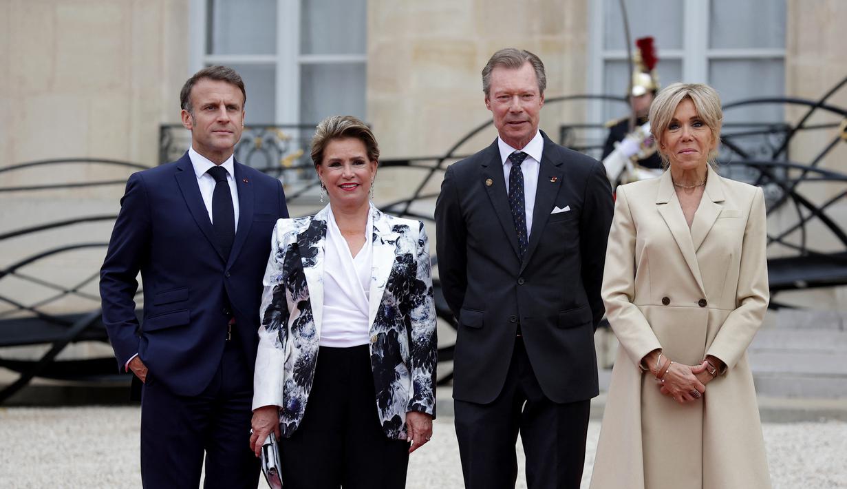 Presiden Prancis Emmanuel Macron (Kiri) dan istrinya Brigitte Macron (kanan) menyambut Grand Duke (Adipati Agung) Henri dan Duchess Maria Teresa dari Luxemburg menjelang upacara pembukaan Olimpiade Paris 2024, di istana presiden Elysee, Kamis (26/7/2024). (Valentine CHAPUIS / AFP)