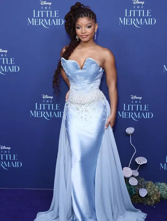 Halle Bailey tampil menawan dalam gaun strapless buatan Off White. Gaun light blue satin ini memiliki detail kerang di dada dan payet di bagian pinggang [@hallebailey]