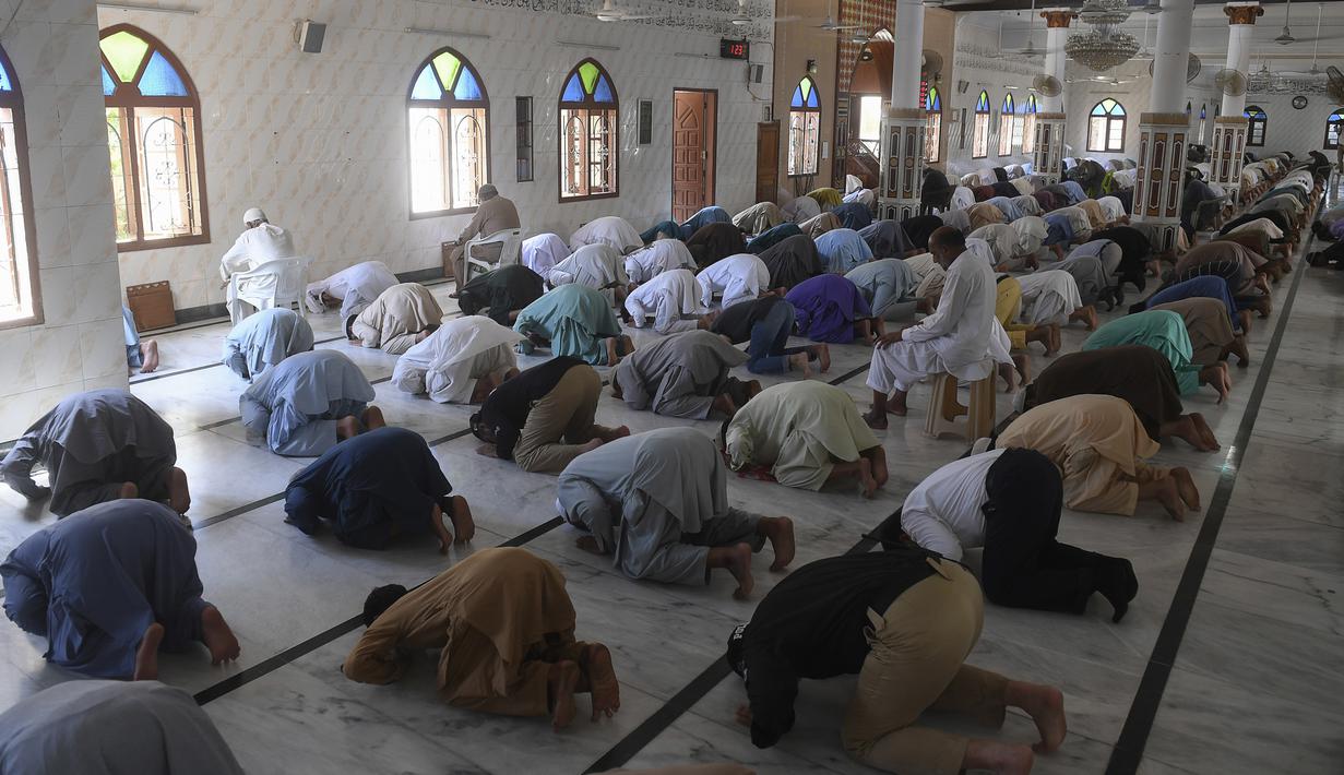 Umat muslim menerapkan jaga jarak aman atau physical distancing saat melaksanakan salat Jumat berjemaah selama Ramadan di sebuah masjid di Karachi, Pakistan, Jumat (1/5/2020). Umat muslim dunia melaksanakan Ramadan tahun ini di tengah pandemi COVID-19. (Asif HASSAN/AFP)