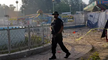 Petugas polisi Pakistan berjaga di lokasi bom bunuh diri di taman Gulshan e Iqbal Park di Lahore, Pakistan, Senin (28/3). Korban tewas akibat ledakan bom tersebut mencapai sekitar 69 orang. (AFP/ARIF ALI)