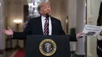 Presiden Donald Trump mengangkat sebuah surat kabar dengan tajuk utama bertuliskan "Trump dibebaskan" selama acara perayaan kemenangan, satu hari setelah upaya pemakzulannya dibatalkan di Ruang Timur Gedung Putih, Washington (6/2/2020). (AP Photo/Evan Vucci)