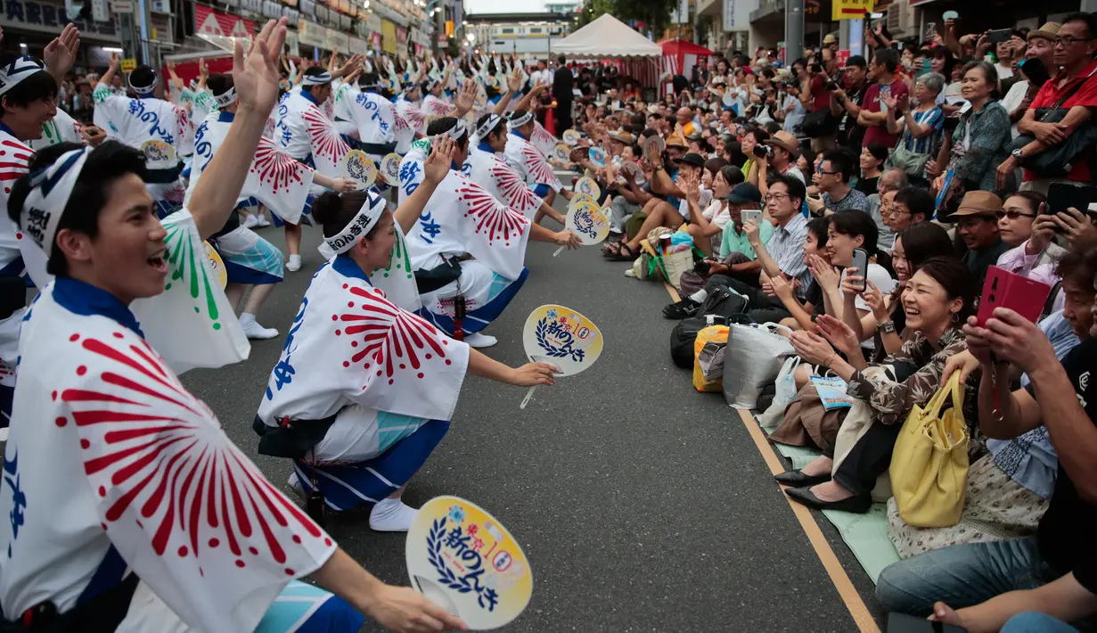 Penari menghibur penonton selama festival tari Koenji Awa-Odori di kawasan Koenji, Tokyo pada 24 Agustus 2019. Ribuan orang menyaksikan tontonan musim panas yang diadakan pada akhir pekan terakhir bulan Agustus setiap tahun selama dua hari. (AP/Jae C. Hong)