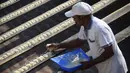 Joseph Sekar menyiapkan makan untuk burung Parkit di Chennai, India, Jumat (17/3). Joseph Sekar menjelaskan dalam sehari ia menghabiskan uang sebesar 425 Rupee (6 USD) untuk memberi makan burung Parkit peliharaannya. (AFP PHOTO / ARUN Sankar)