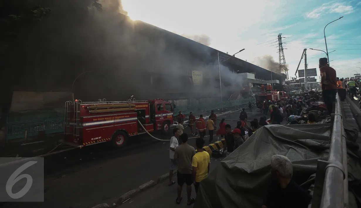 Warga tampak ramai ingin melihat proses pemadaman kebakaran yang melanda pusat perbelanjaan Pasar Senen, Jakarta Pusat, Kamis (19/1). Petugas belum dapat menyimpulkan nilai kerugian dan korban jiwa karena kebakaran tersebut. (Liputan6.com/Faizal Fanani)