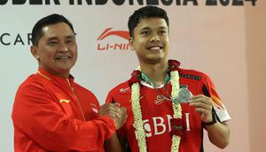 Pebulu tangkis Indonesia, Anthony Sinisuka Ginting (kanan) memperlihatkan medali runner up Thomas Cup 2023 saat berfoto bersama dengan Sekjen PP PBSI, Fadil Imran di Gedung VVIP Terminal 3 Bandara Soekarno Hatta, Tangerang, Banten, Senin (06/05/2024). (Bola.com/M Iqbal Ichsan)