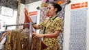 Pegawai merapikan kain batik yang dipajang pada acara Relaunching Batik Keris Online di Bekraf Habibie Festival 2017 Jakarta. Batik Keris mulai merambah ke Online hadir dengan tampilan dan fitur yang terbaru. (Liputan6.com/Pool)