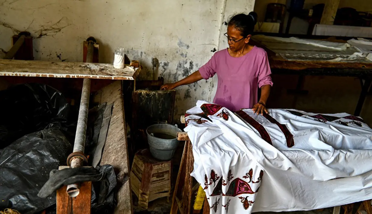 Seorang pekerja membuat desain batik di sebuah bengkel di Banda Aceh, Aceh, Rabu (13/10/2021). Untuk warna yang dominan dipakai dalam batik Aceh adalah warna cerah seperti merah muda, merah, kuning, hijau dan lainnya. (Chaideer MAHYUDDIN/AFP)
