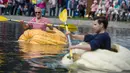 Juergen Herrmann dan Christoph Zimmermann berpartisipasi dalam lomba tradisional mendayung buah labu di Fambach, Jerman, Minggu (10/9). Perlombaan melibatkan beberapa perahu dari labu raksasa, dalam jalur sepanjang 200 meter. (Jens-Ulrich Koch/dpa via AP)