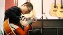 Seorang pria menjajal gitar pada ajang Music China 2020 di Shanghai New International Expo Center, China, 28 Oktober 2020. Music China 2020 diikuti lebih dari 1.000 industri musik dari 11 negara dan kawasan dengan produk-produk baru mereka. (Xinhua/Fang Zhe)
