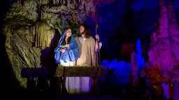 Para pemain menampilkan pertunjukan tentang kisah kelahiran bayi Yesus di Gua Postojna, Slovenia, 20 Desember 2018. Setiap perayaan Natal, Postojna Cave selalu menyajikan pertunjukkan cerita-cerita luhur Umat Kristiani di dalam gua. (Jure Makovec/AFP)