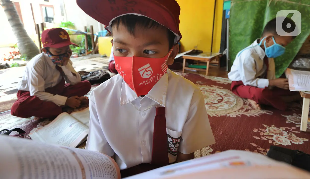 Murid kelas III SDN 02 Pondok Petir mengikuti kegiatan belajar mengajar di teras rumah salah satu siswa di Depok, Senin (31/08/2020). Sudah hampir dua minggu ini, mereka mengadakan pembelajaran secara tatap muka dengan guru yang berkeliling atas permintaan wali murid. (merdeka.com/Arie Basuki)