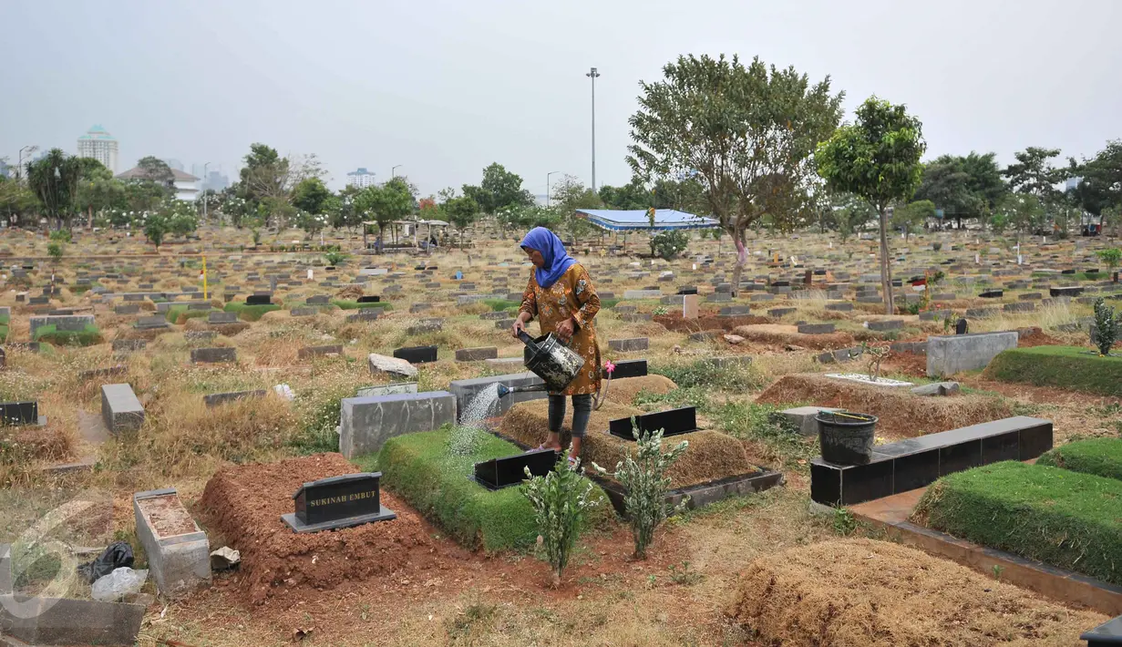 Seorang pekerja menyiram makam di TPU Karet Bivak, Jakarta, Rabu (7/10/2015).  Pengamat Tata Kota dari Universitas Trisakti Nirwono Yoga memprediksi DKI Jakarta akan mengalami krisis lahan makam pada 2017. (Liputan6.com/Gempur M Surya)