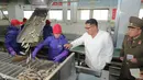 Gambar tak bertanggal yang dirilis pada 19 November 2019, pemimpin Korea Utara Kim Jong-un (kedua kanan) mengunjungi pabrik pengolahan ikan di lokasi yang dirahasiakan di Korea Utara. Kim Jong-un berbicara dengan para pekerja dan sesekali tertawa saat berkeliling pabrik.  STRINGER/KCNA VIA KNS/AFP)