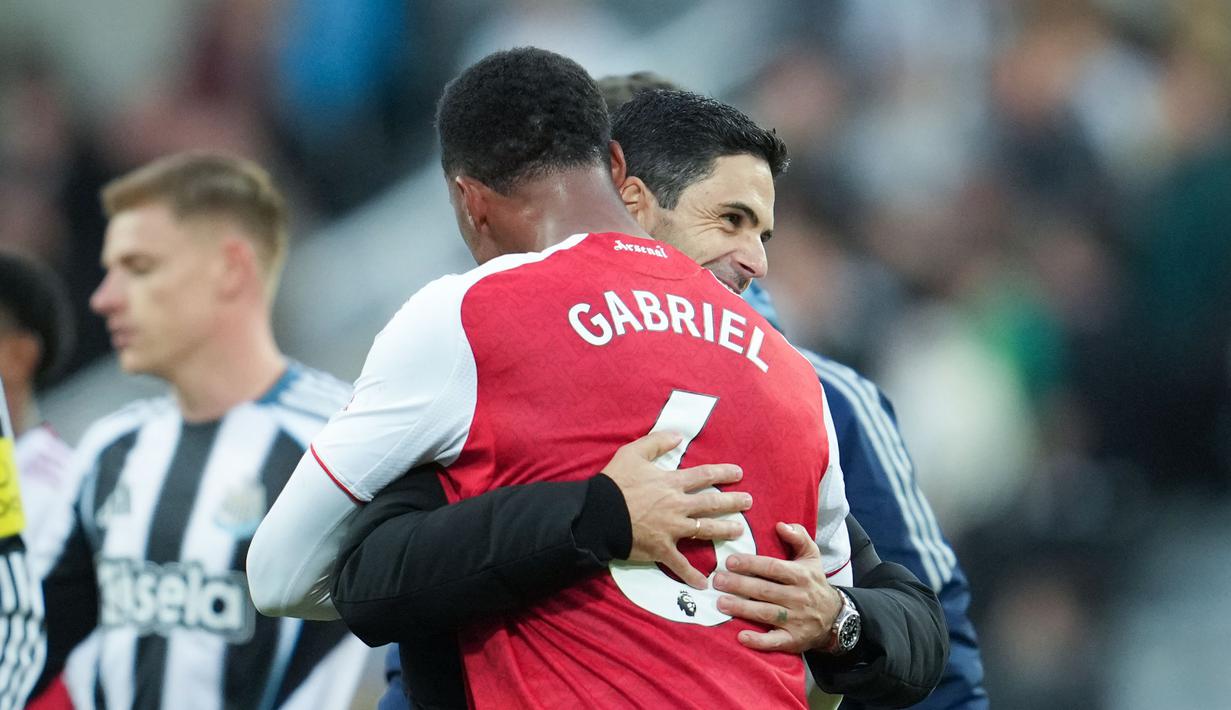 Pelatih Arsenal, Mikel Arteta, memeluk Gabriel Magalhaes, saat merayakan kemenangan atas Newcastle United pada lanjutan Liga Inggris di St James Park, Minggu (28/9/2025). (AP Photo/Jon Super)