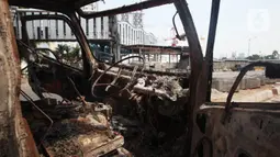 Kondisi mobil proyek yang hangus terbakar saat unjuk rasa menolak pengesahan Undang-Undang Cipta Kerja di kawasan Senen, Jakarta, Jumat (9/10/2020). Unjuk rasa tersebut berakhir ricuh dan mengakibatkan sejumlah fasilitas umum rusak. (Liputan6.com/Angga Yuniar)