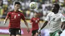 Gelandang Mesir Emam Ashour berebut bola dengan penyerang Senegal Ismaila Sarr pada Kualifikasi Piala Dunia 2022 zona Afrika di Stade Me Abdoulaye Wade, Rabu (30/3/2022) dini hari WIB. Senegal dipastikan lolos ke Piala Dunia 2022 setelah menang adu penalti atas Mesir 3-1. (SEYLLOU / AFP)