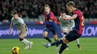 Penyerang Barcelona, Dani Olmo, melakukan eksekusi penalti ketika menghadapi Osasuna di Estadi Olimpic Lluis Companys, Jumat (28/3/2025) dini hari WIB. (LLUIS GENE / AFP)