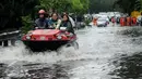 Warga dibantu mobil amfibi melewati genangan air di depan kampus UKRIDA, Jakarta, Selasa (21/1). Hujan deras sejak malam tadi, membuat sejumlah wilayah Jakarta tergenang air banjir. (Liputan6.com/Gempur M Surya)