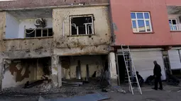 Warga tampak memperbaiki rumahnya yang rusak akibat konflik antara Militer Turki dan Militan Kurdi di Turki, (7/12). Pemberontakan dengan pasukan pemerintah Turki ini yang terjadi  sejak 1984 ini sudah menewaskan 40 ribu orang. (REUTERS/Murad Sezer)