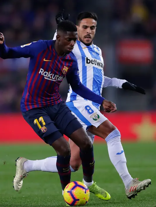 Pemain Barcelona, Dembele berebut bola dengan pemain Leaganes, Jose Luis Garcia pada pertandingan pekan ke-20 La Liga Spanyol, di Camp Nou, Senin (21/1). Barcelona kian kokoh di puncak klasemen usai menang 3-1 atas Leganes. (AP/Manu Fernandez)