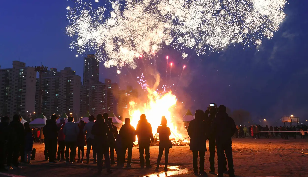Peserta menyaksikan kembang api menjelang perayaan "Jeongwol Daeboreum" di Seoul, Korea Selatan (1/3). Jeongwol Daeboreum merupakan perayaan hari libur tradisional Korea untuk merayakan bulan purnama pertama kalender lunar. (AFP Photo/Jung Yeon-je)