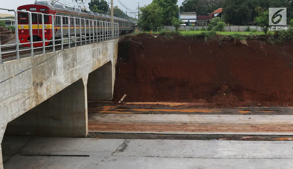 Kereta listrik melintas diatas proyek jalan tol Cijago Seksi II di kawasan Depok, Jawa Barat, Senin (2/10). Kendala pembebasan lahan membuat jalan bebas hambatan sejauh 14,6 km itu baru mentok di belakang Kampus UI. (Liputan6.com/Immanuel Antonius)
