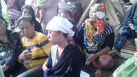 Sang istri, Ribka terisak mendapati kondisi suami dan anak semata wayangnya tak selamat akibat longsor di Manado. (Liputan6.com/Yoseph Ikanubun)