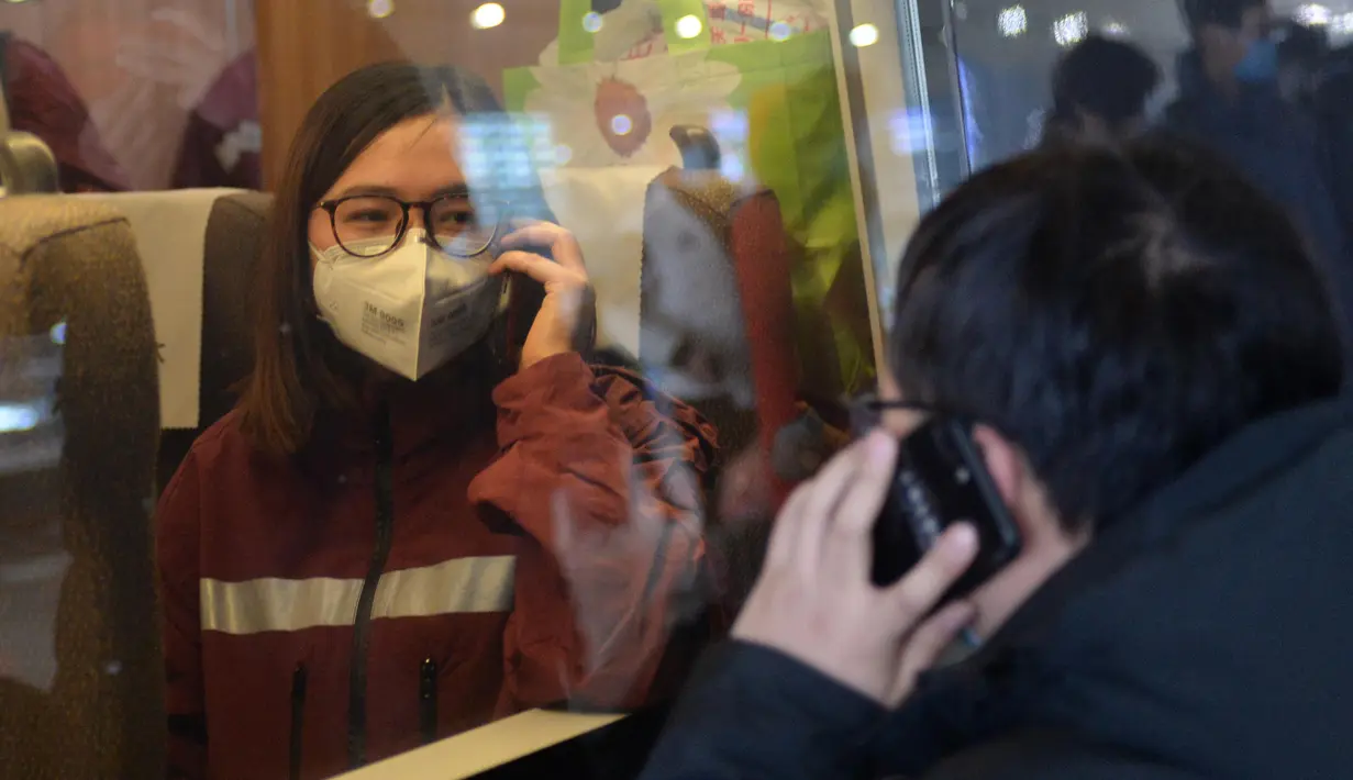 Anggota tim medis (kiri) dari Rumah Sakit Xiangya Kedua di bawah naungan Central South University berpamitan dengan anggota keluarganya melalui ponsel sebelum berangkat menuju Wuhan, di Stasiun Kereta Api Selatan Changsha, China, pada 8 Februari 2020. (Xinhua/Chen Zhenhai)