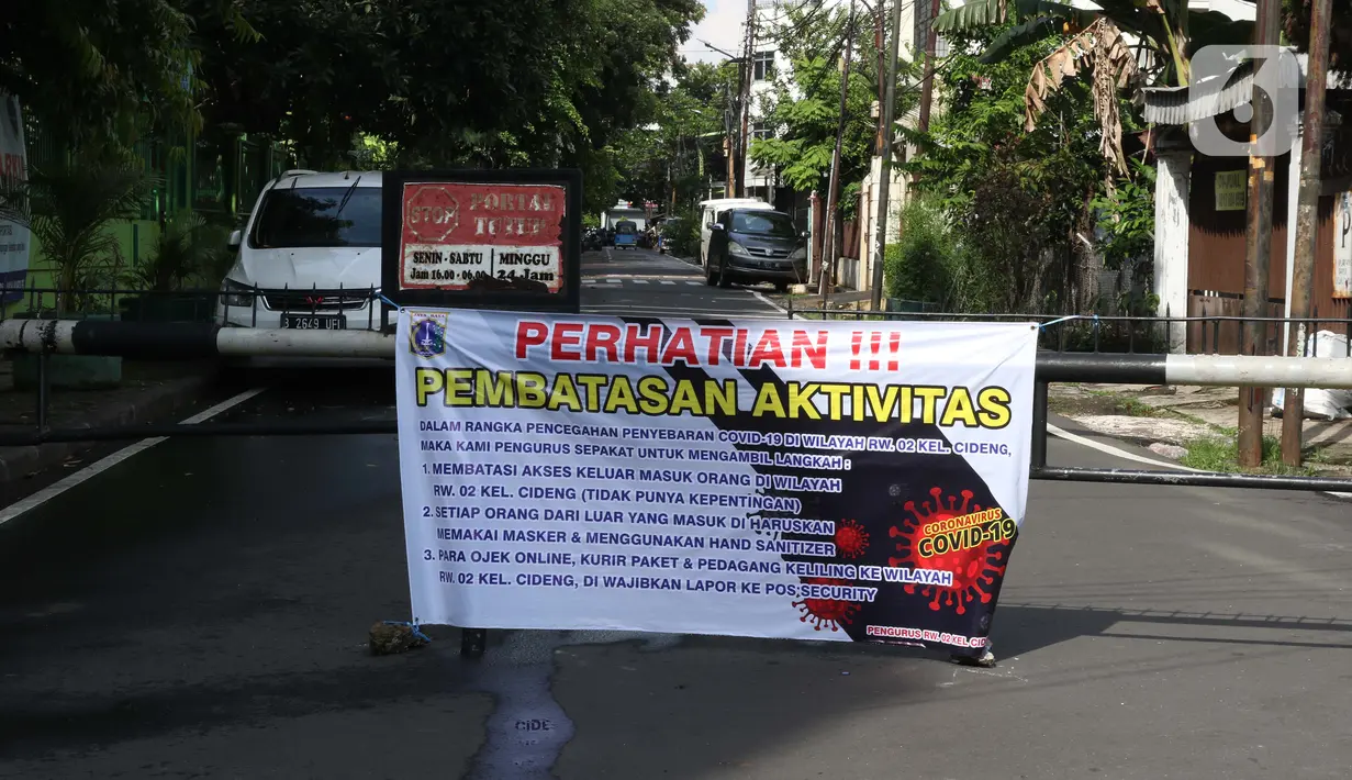 Spanduk tentang pembatasan aktivitas terpampang di pintu masuk perumahan di kawasan Cideng, Jakarta, Kamis (2/4/2020). Pemerintah menetapkan Pembatasan Sosial Berskala Besar dengan membatasi kegiatan tertentu penduduk di wilayah yang diduga terinfeksi COVID-19. (Liputan6.com/Helmi Fithriansyah)