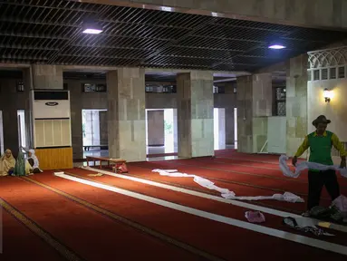 Petugas merapikan karpet untuk persiapan salat tarawih di Masjid Istiqlal, Jakarta, Rabu (17/6/2015). Warga Muslim di Indonesia bersiap menjalankan ibadah puasa 1436 H dengan ditandai pelaksanaan salat sunat tarawih. (Liputan6.com/Faizal Fanani) 