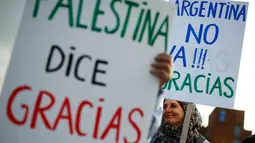 Aktivis pro-Palestina menunjukkan poster ungkapan terima kasih kepada timnas sepak bola Argentina di Barcelona (6/6). Selain aktivis ini, para pejabat sepak bola Palestina memuji Argentina dan bintangnya, Lionel Messi. (AFP Photo/Pau Barrena)