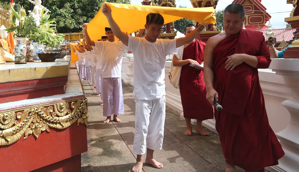 11 anak laki-laki bersama pelatih mereka, yang diselamatkan dari gua di Thailand, menjalani upacara pentahbisan di Kuil Wat Phra That Doi Wao, Selasa (24/7). Sebanyak 11 dari 12 remaja itu menjalani ritual menjadi biksu selama 9 hari. (AP /Sakchai Lalit)