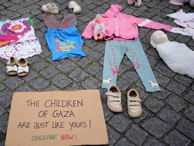 Sebuah instalasi pakaian dan mainan anak-anak tersebar di sepanjang jalan Carmo di pusat kota Lisbon, Portugal, Jumat, 30 Mei 2025. (AP Photo/Armando Franca)