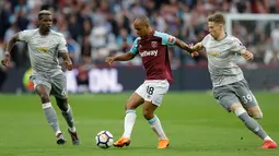 Pemain West Ham United Joao Mario membawa bola berusaha melewari pemain Manchester United pada pertandingan Liga Inggris di London Stadium di London (10/5). Pertandingan ini berakhir dengan skor 0-0. (AP Photo / Alastair Grant)