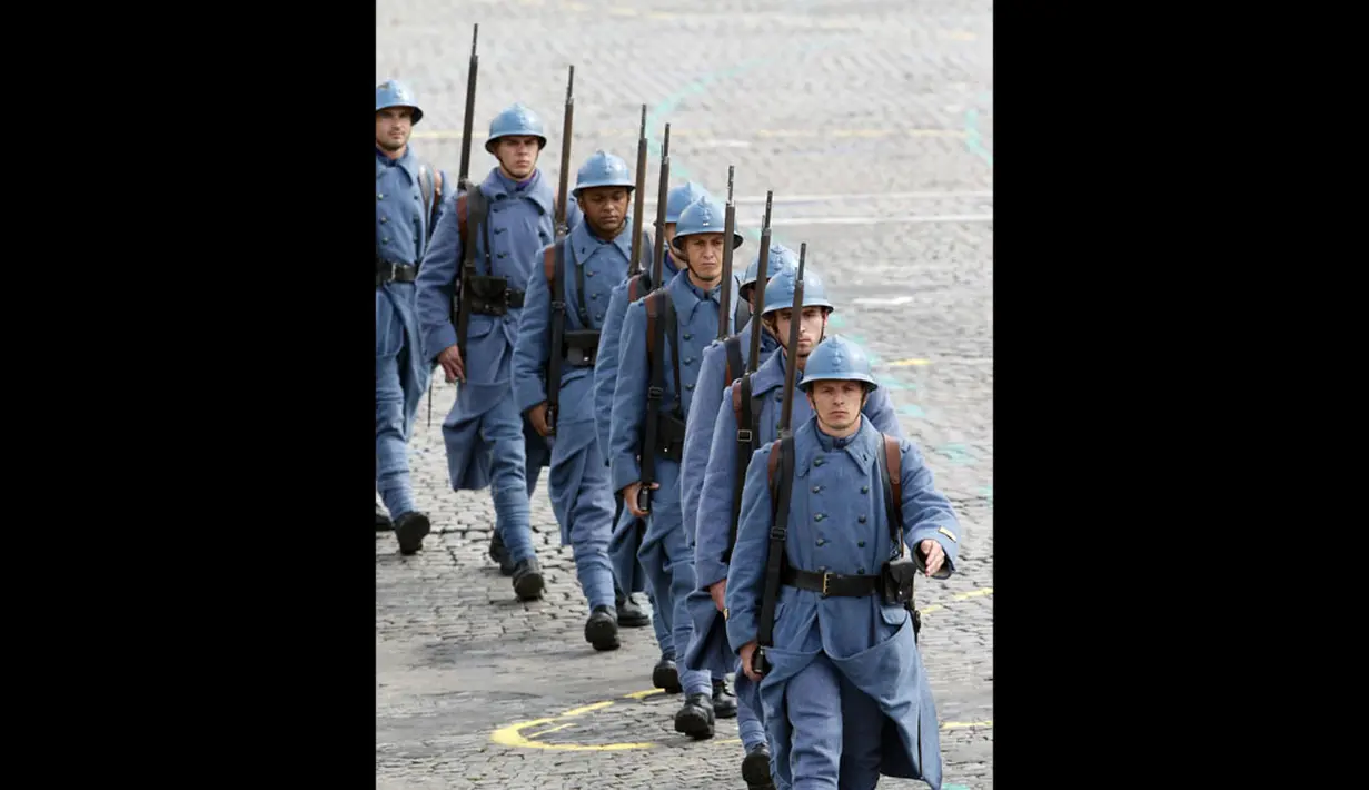 Berseragam ala tentara Perancis saat Perang Dunia I, sepasukan serdadu ikut ambil bagian dalam perayaan peringatan Bastile Days 2014 di jalan Champs Elysees, Paris, (14/7/2014). (REUTERS/Pascal Rossignol)